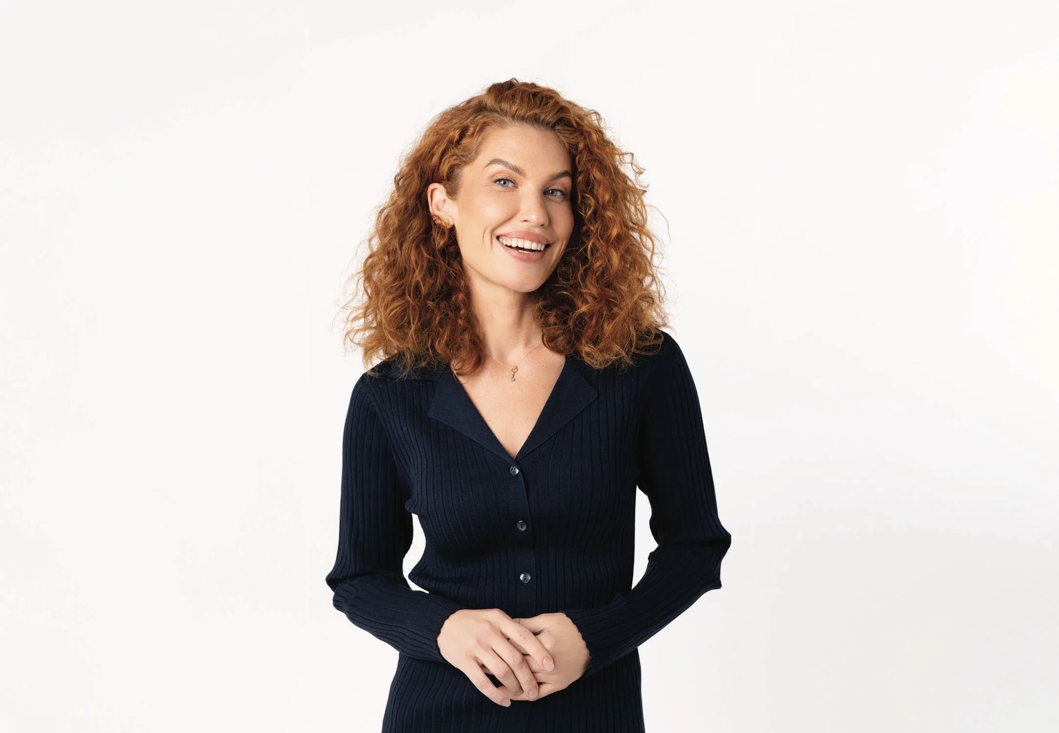 Een vrouw met krullend haar lacht breed